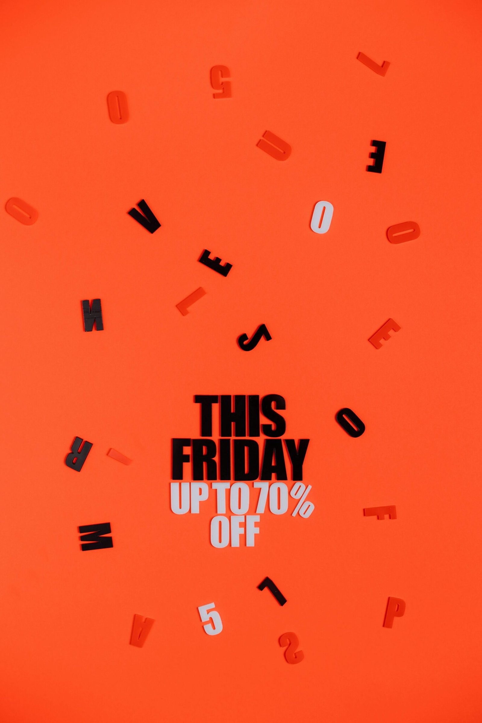 Bold Black Friday sale promotion with scattered letters on bright orange background.